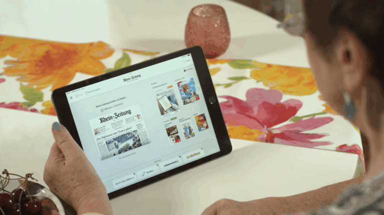 Tisch mit Tablet, mit Abbildung der E-Paper App der Rhein-Zeitung