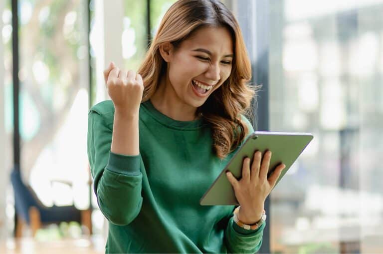 Frau lacht mit Tablet in der Hand